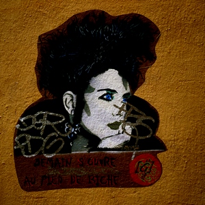 Mur orange et tête de femme aux cheveux noirs et yeux bleus, inscription demain s'ouvre au pied de biche - France  - collection de photos clin d'oeil, catégorie streetart